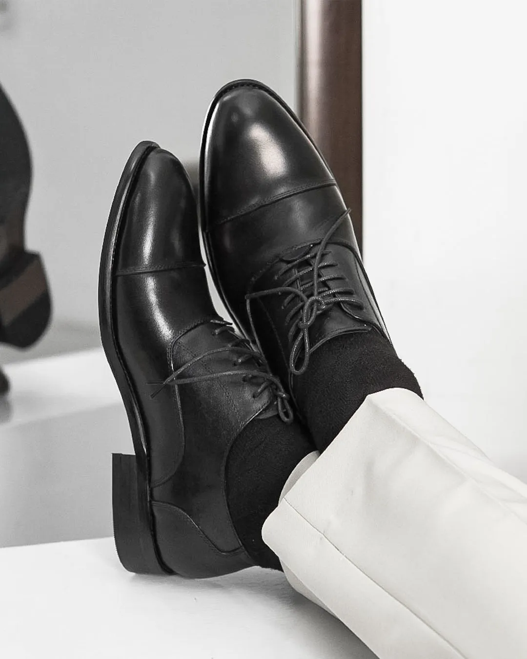 Black Oxford Cap Toe Lace Up shoe.